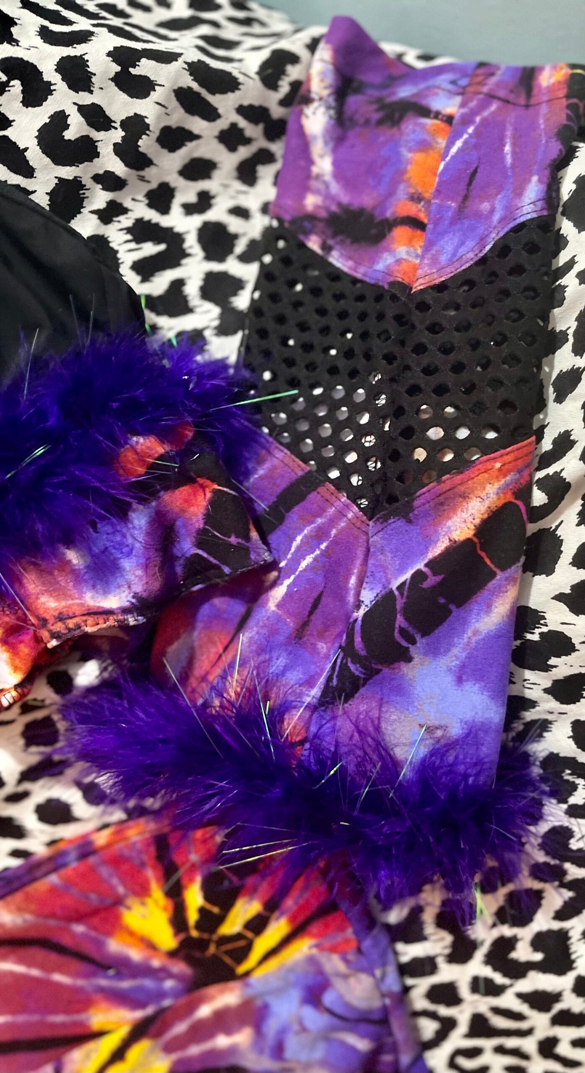 A pair of purple and black leopard print leggings on a bed.