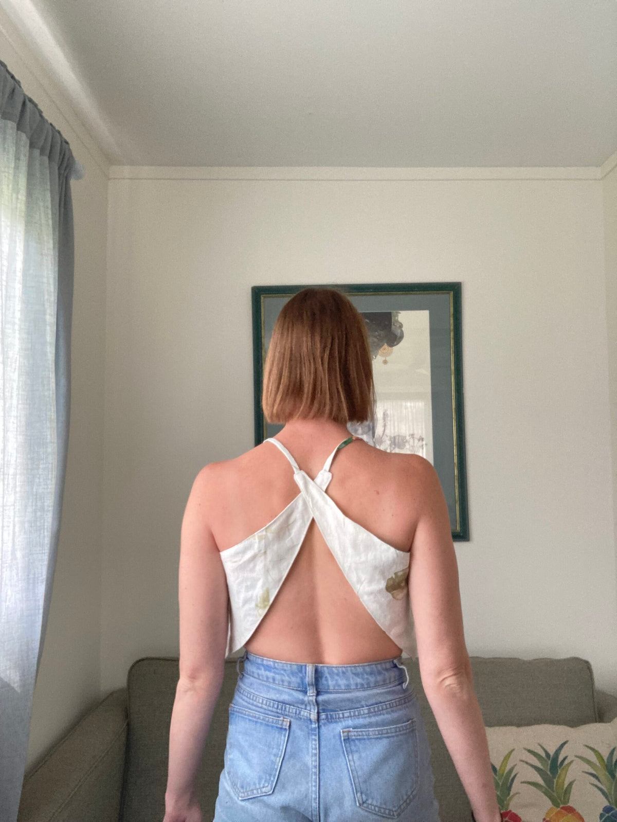 A woman standing in a living room with her back to the camera.