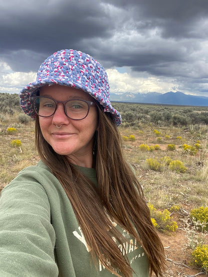 A woman wearing a hat in the desert.