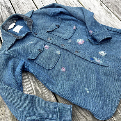 A blue denim shirt with flowers on it.