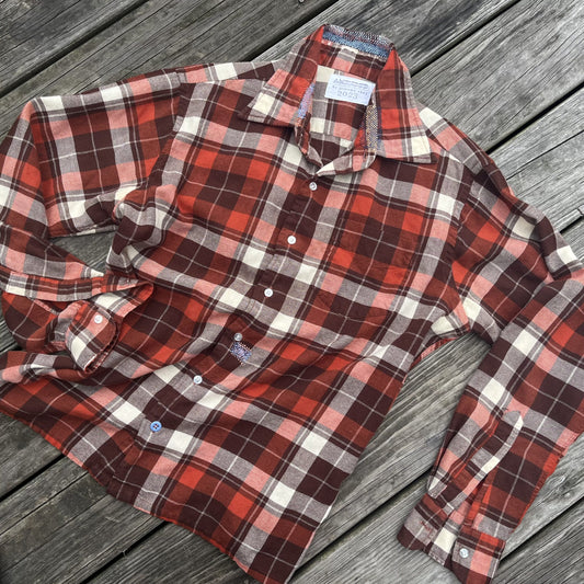 An orange and white plaid shirt on a wooden deck.