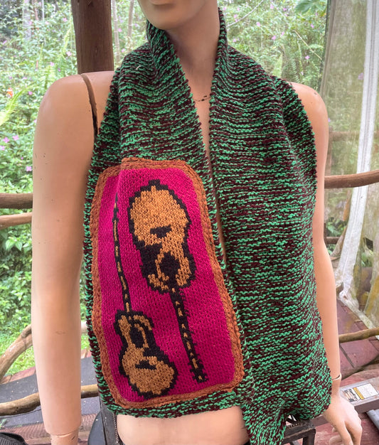 A mannequin wearing a knitted scarf with a guitar on it.