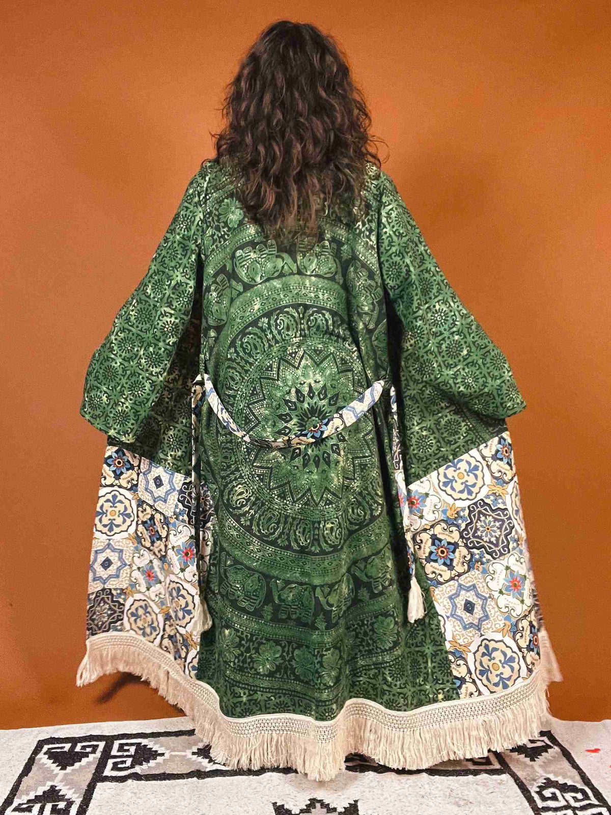 a woman in a green dress standing on a rug.