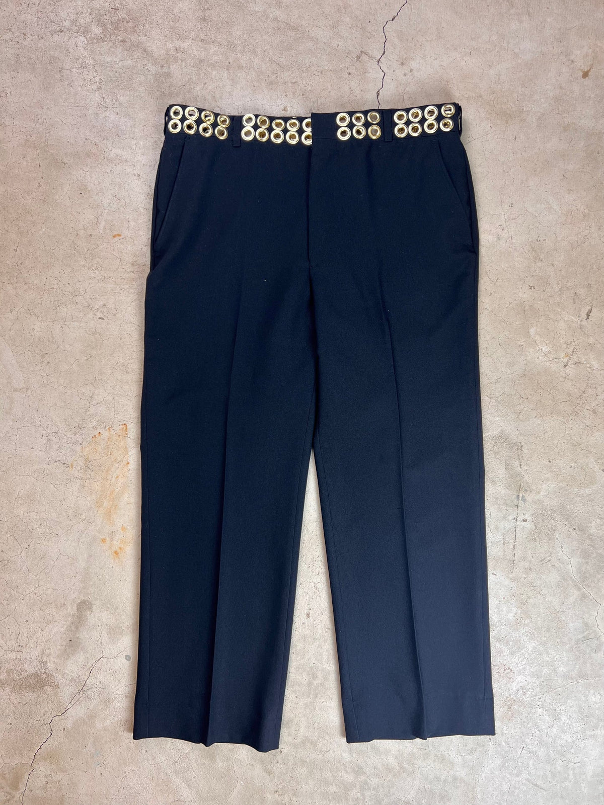 Navy blue trousers with gold button details at the waistband.