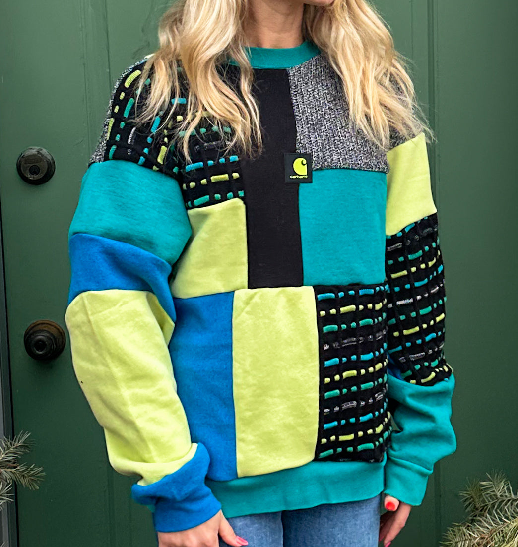 A woman wearing a colorful sweater in front of a door.