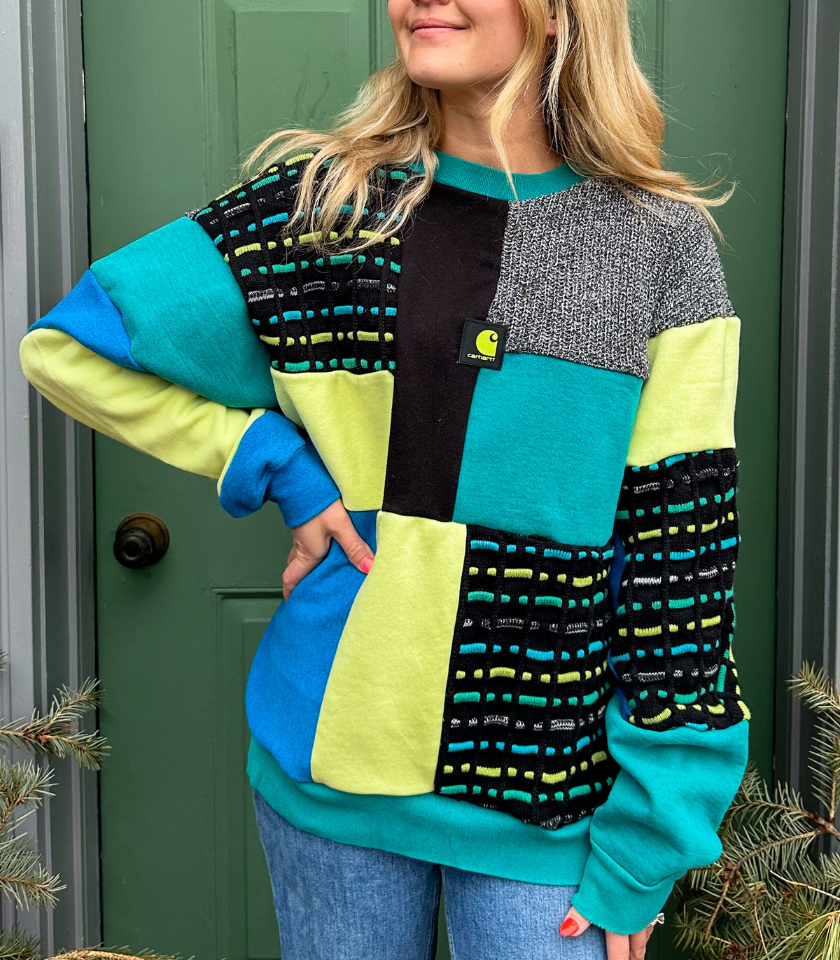 A woman wearing a colorful sweater and jeans.