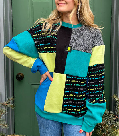 A woman wearing a colorful sweater and jeans.