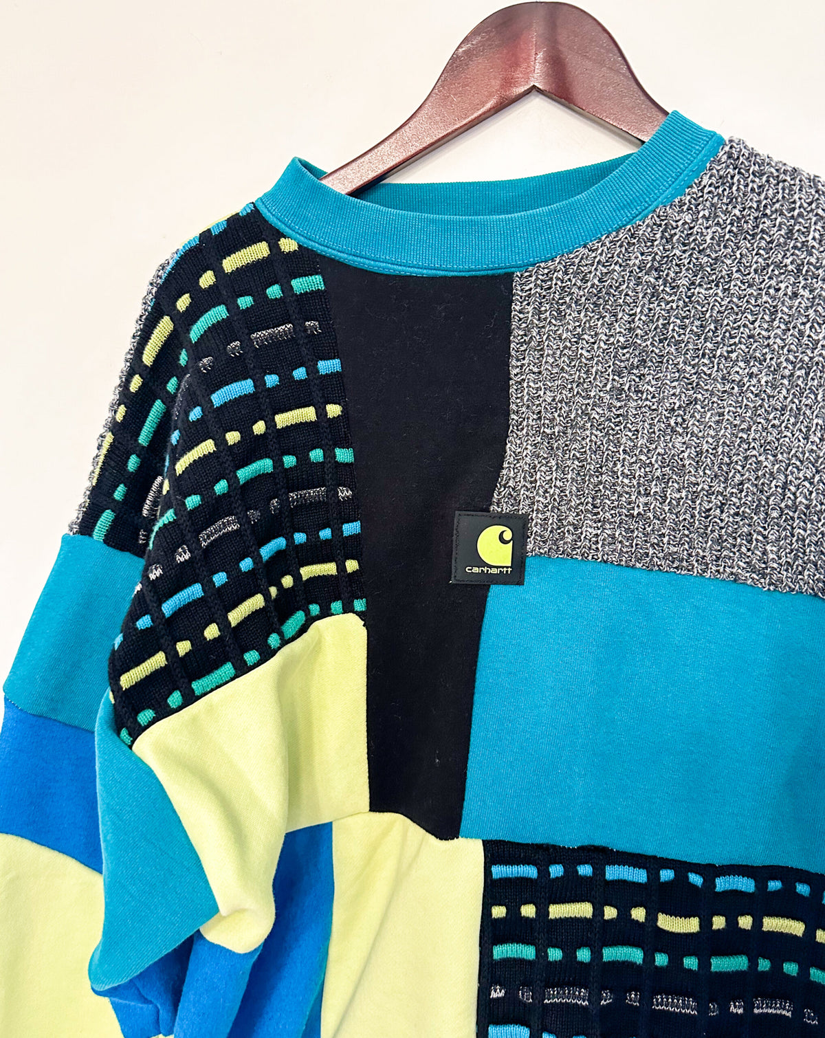 A sweater with a blue, yellow, and blue patch on it.