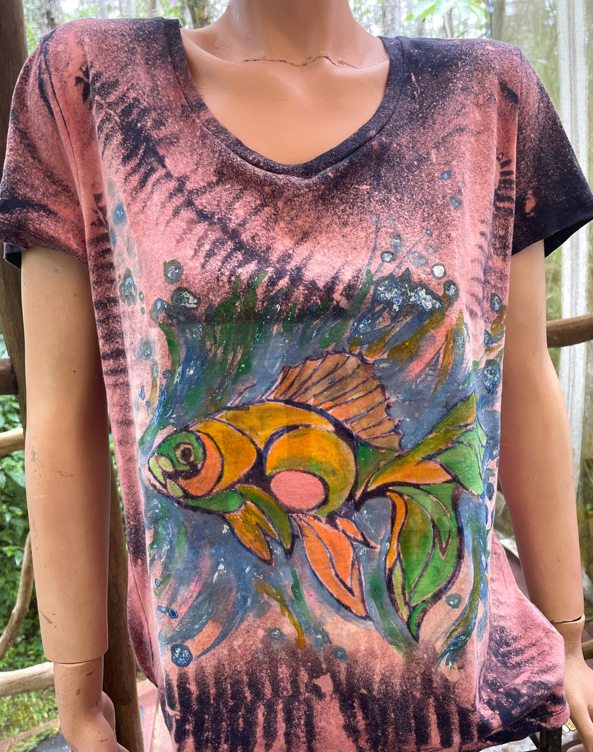 A mannequin wearing a t - shirt with a fish on it.