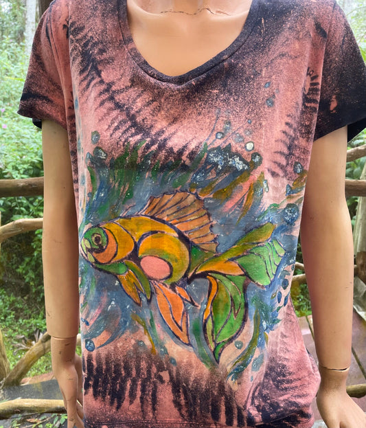 A woman wearing a t - shirt with a gold fish on it.