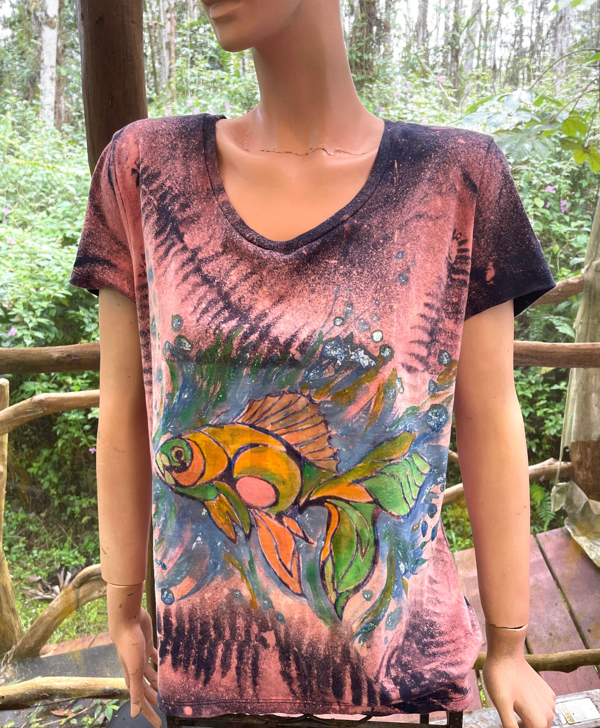 A mannequin wearing a t - shirt with a fish on it.