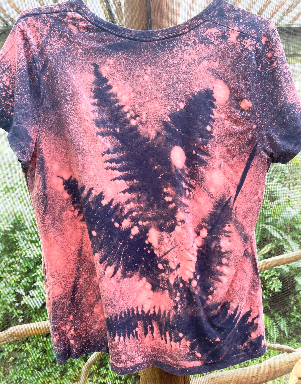 The back of a tie dye t - shirt with ferns on it.