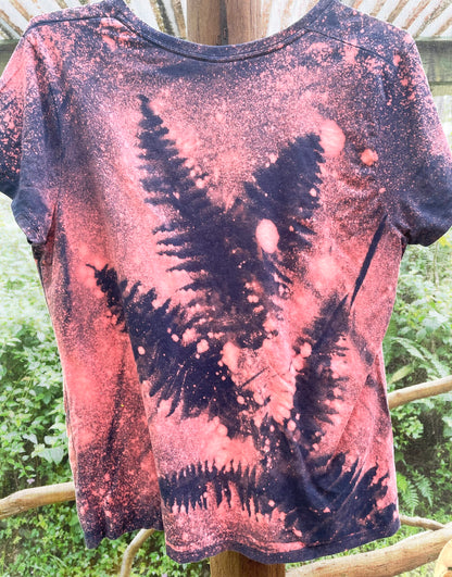 The back of a tie dye t - shirt with ferns on it.