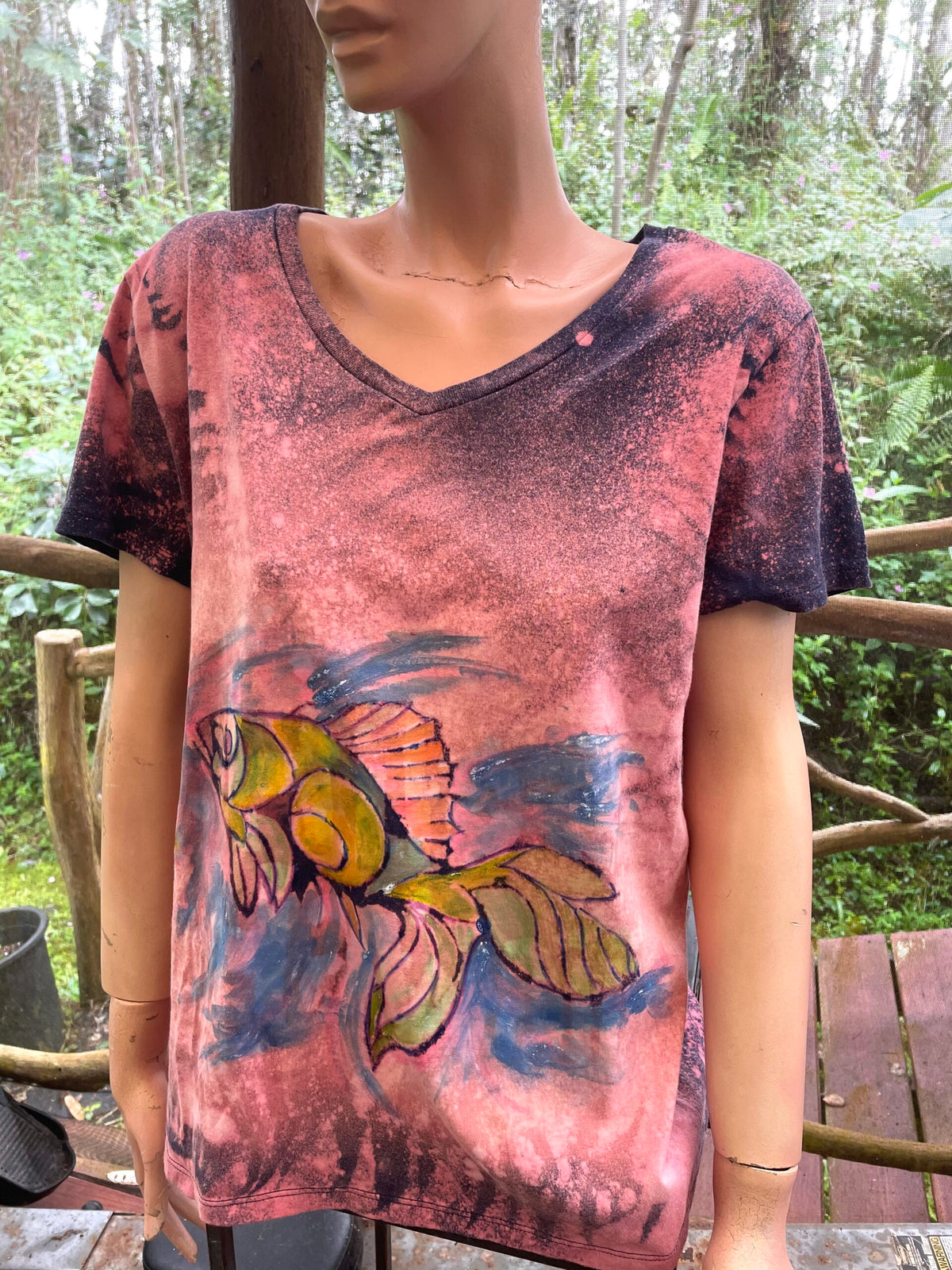 A mannequin wearing a t - shirt with a fish on it.