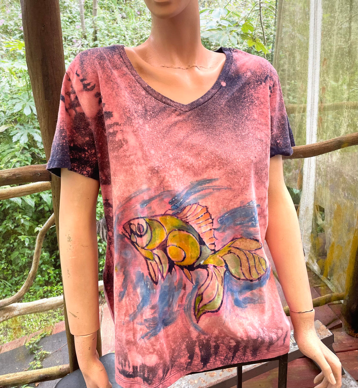 A mannequin wearing a t - shirt with a fish on it.