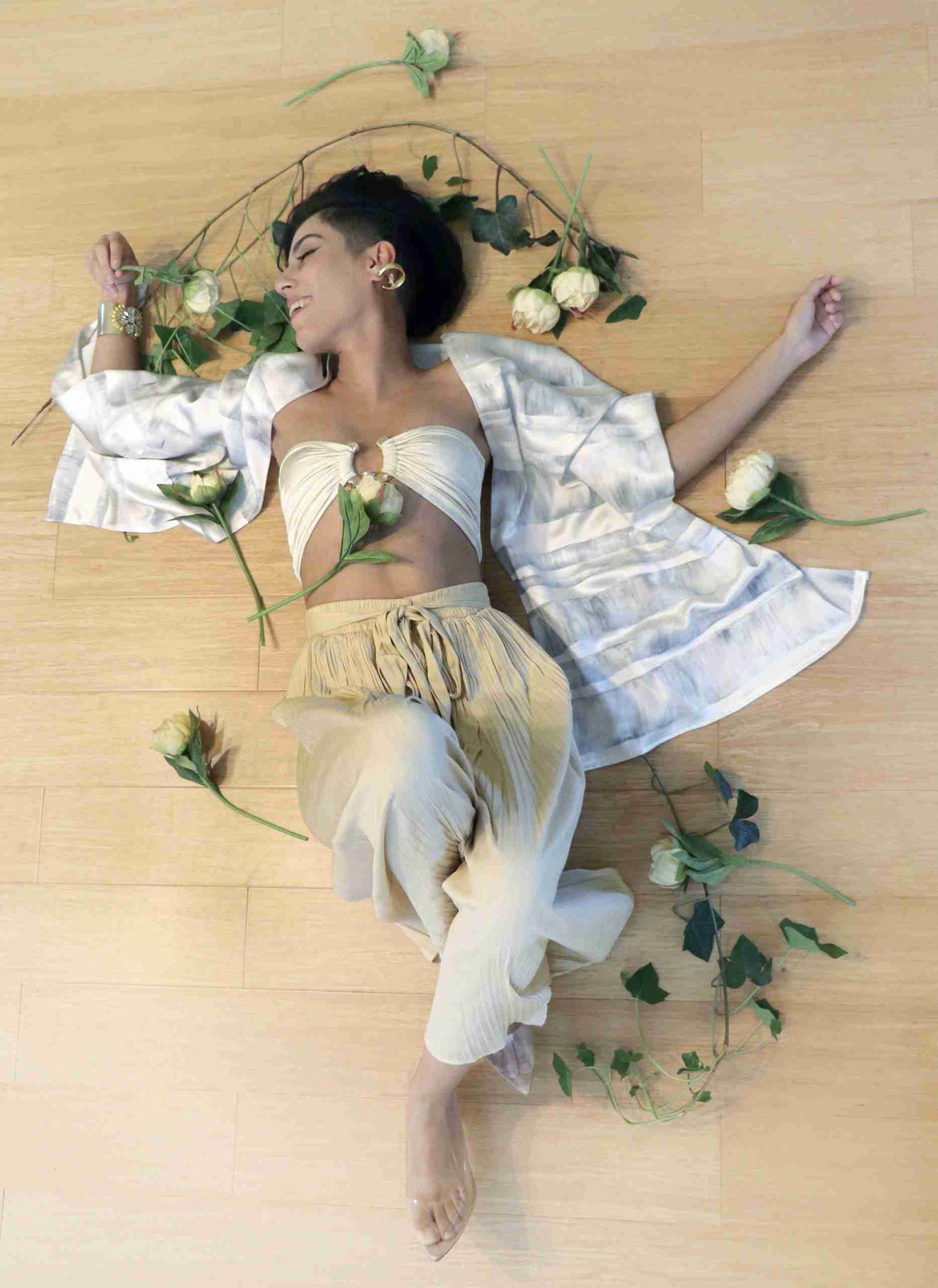 a woman laying on the floor with flowers around her.