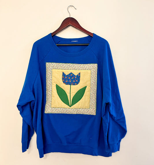 A blue sweatshirt with a tulip on it.