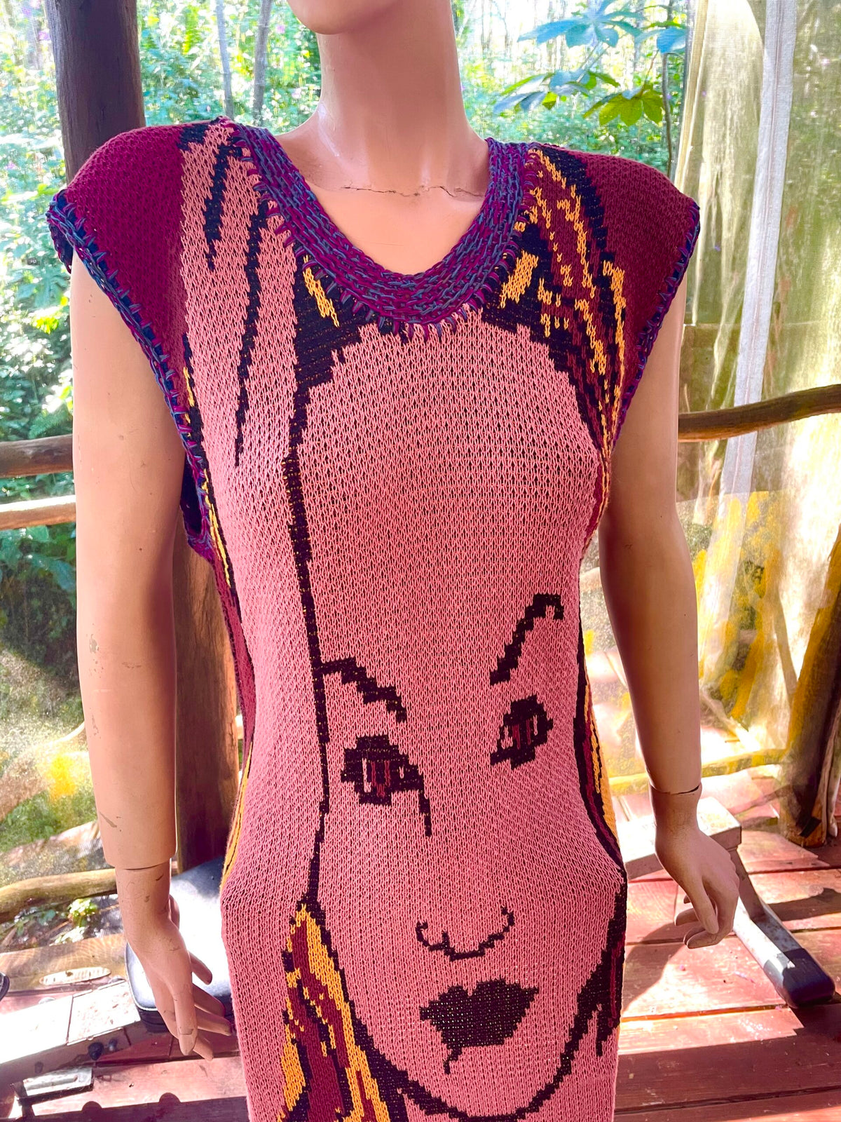 A mannequin wearing a crocheted dress with a face on it.
