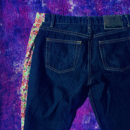 a pair of jeans sitting on top of a purple blanket.