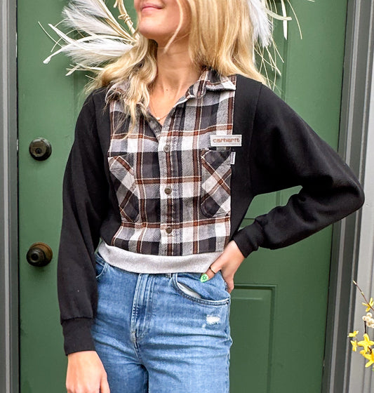 A woman wearing ripped jeans and a plaid shirt.