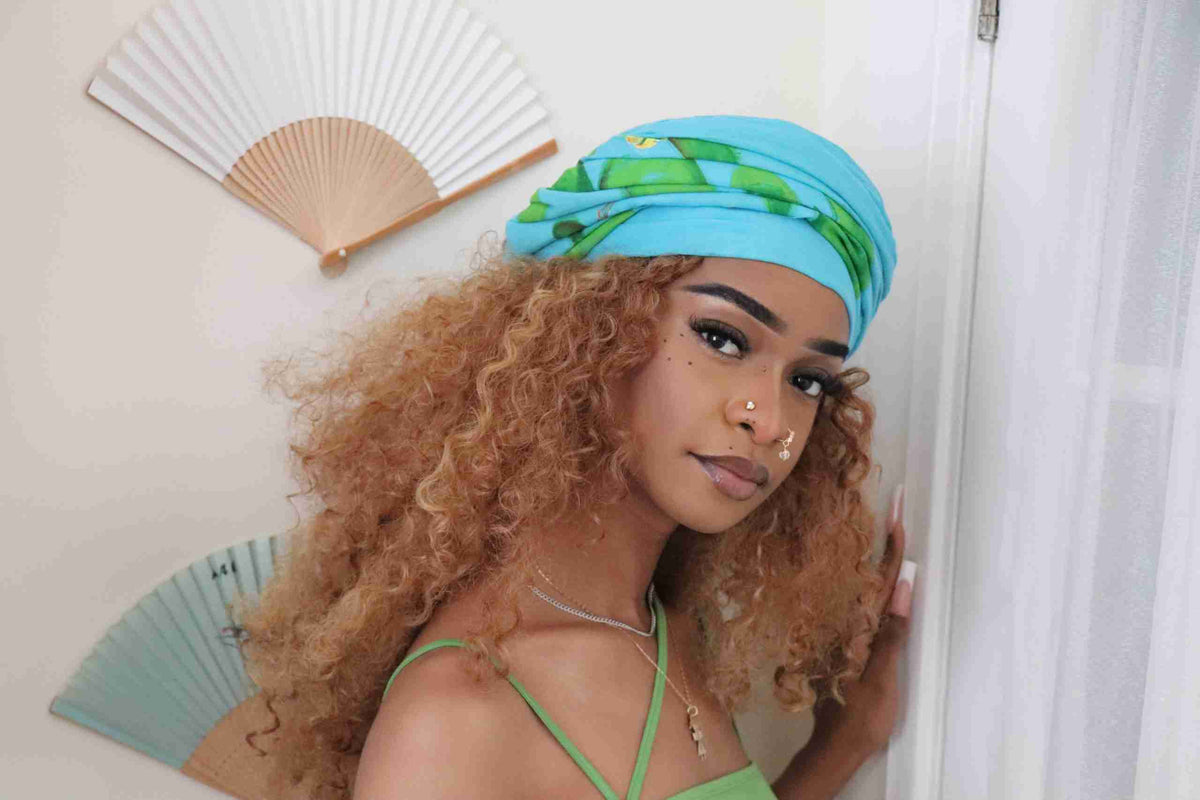 a woman with curly hair wearing a blue bandana.