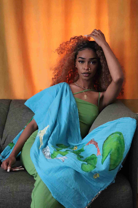 a woman sitting on a couch with a blue blanket.