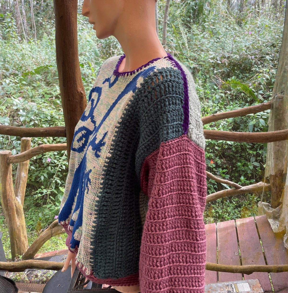 A mannequin mannequin wearing a crocheted sweater.
