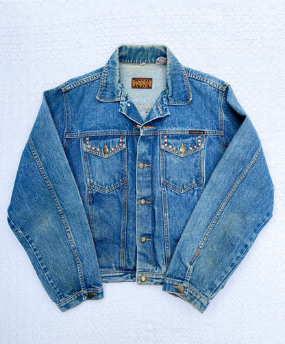 A denim jacket with a beading on it.