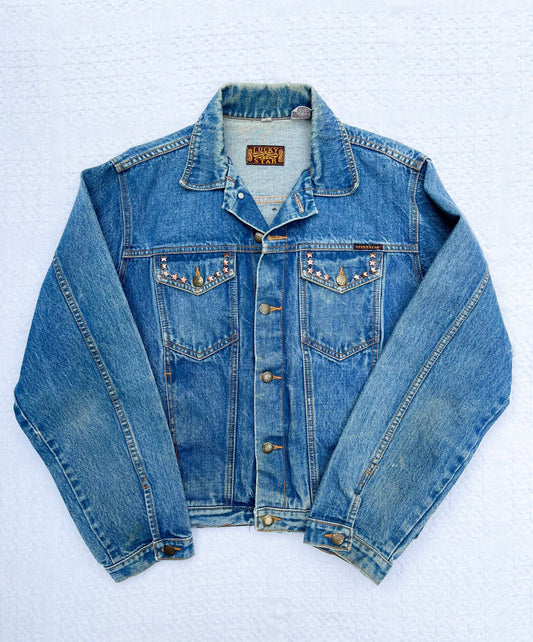 A denim jacket with a beading on it.