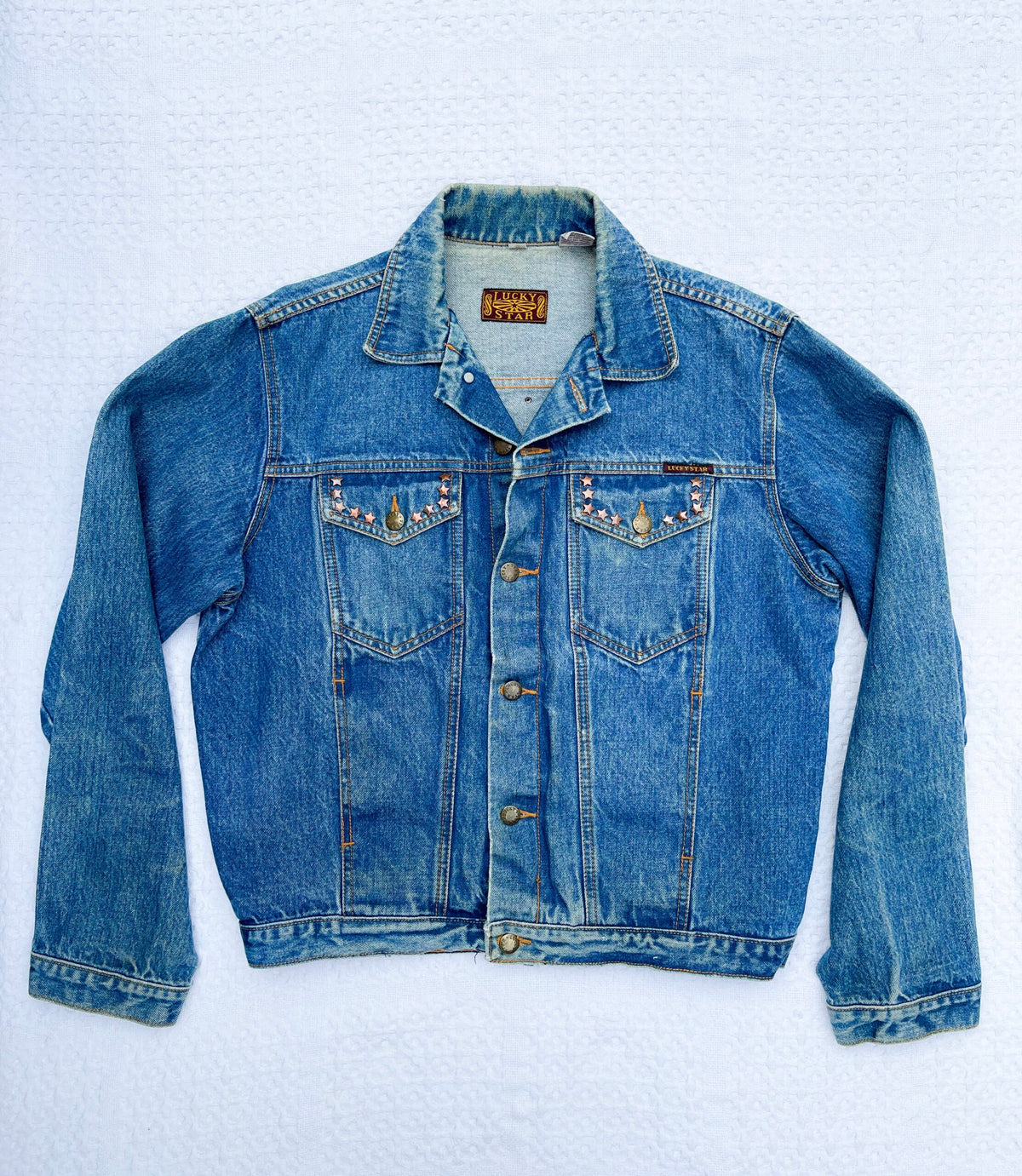 A blue denim jacket on a white background.