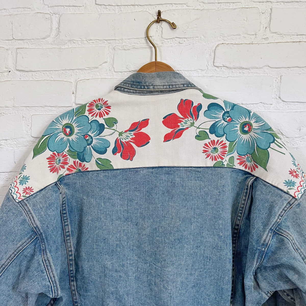 A denim jacket with flowers on it.