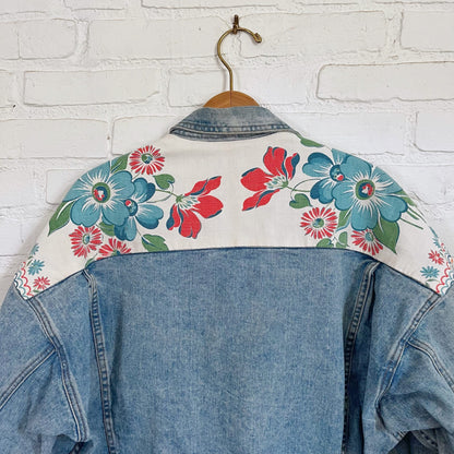 A denim jacket with flowers on it.