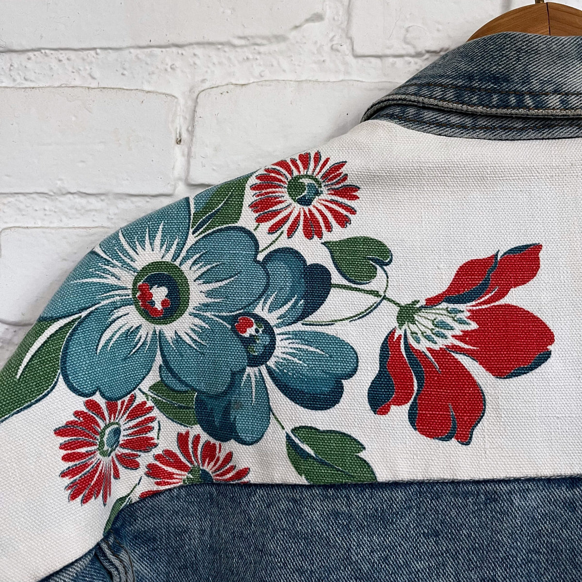 A denim jacket with flowers on it.
