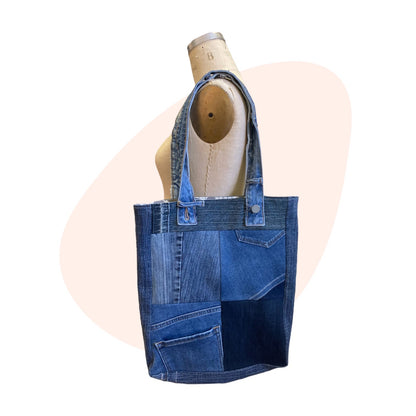 A blue denim tote bag on a mannequin.