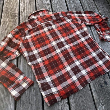 An orange and white plaid shirt on a wooden deck.