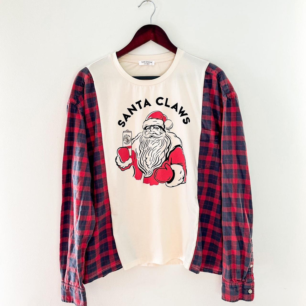 A santa clause shirt hanging on a hanger.