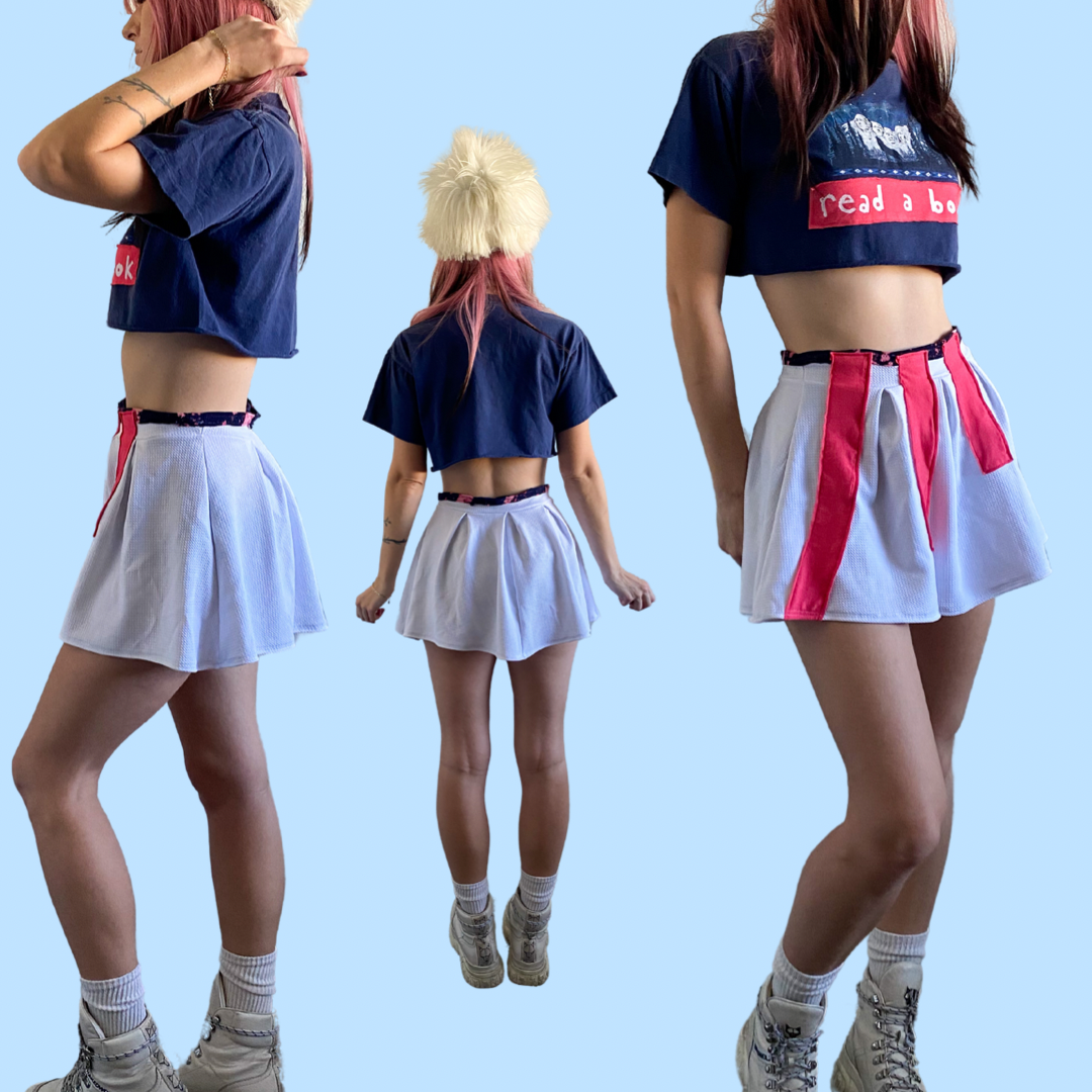 A woman wearing a skirt and a crop top.