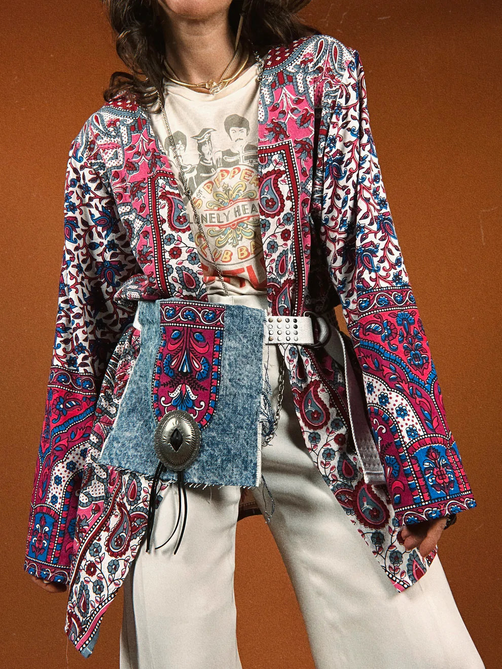a woman wearing a colorful jacket and white pants.
