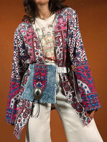 a woman wearing a colorful jacket and white pants.