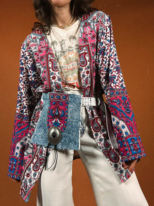 a woman wearing a colorful jacket and white pants.