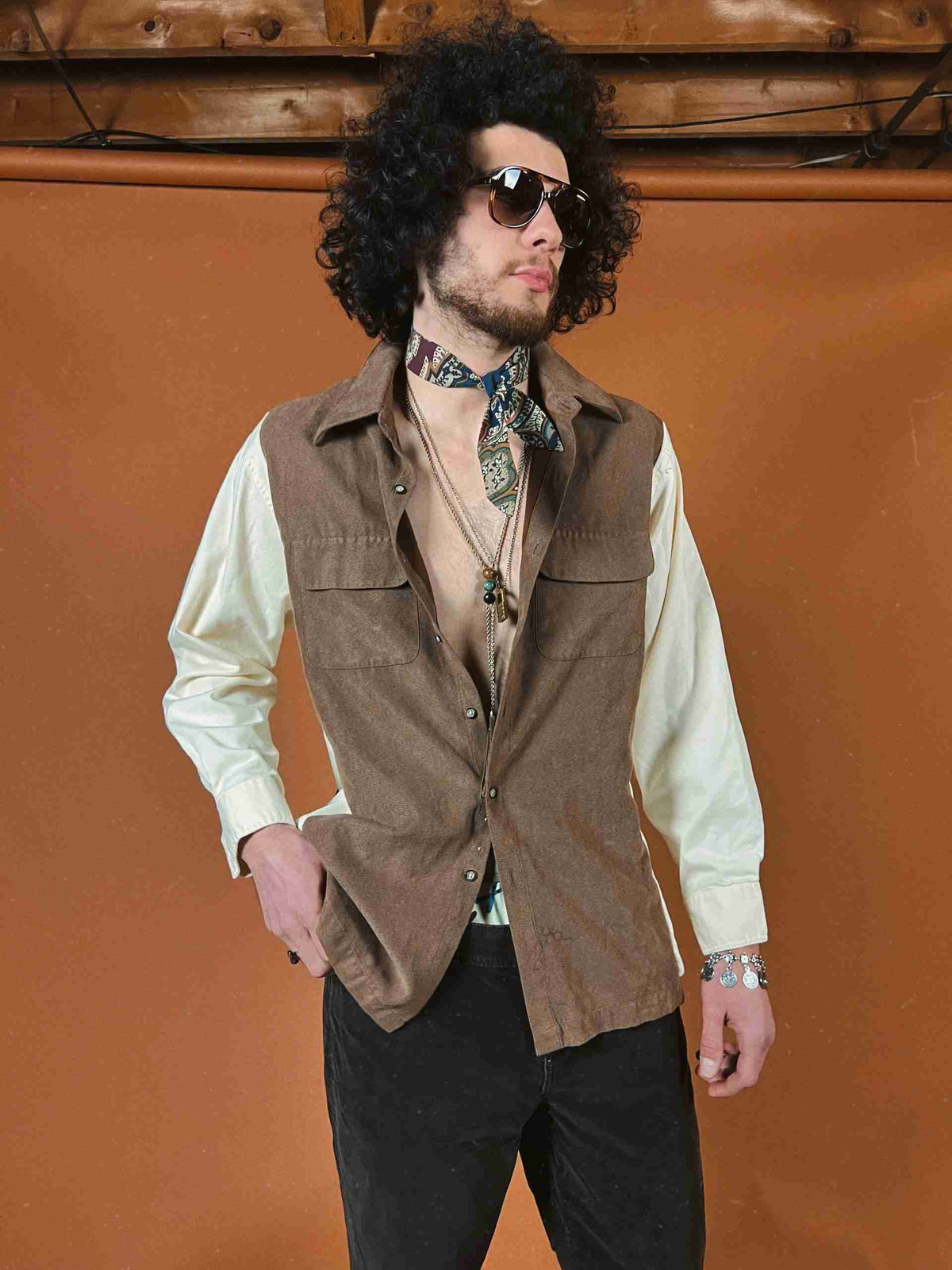a man in a brown vest and tie.