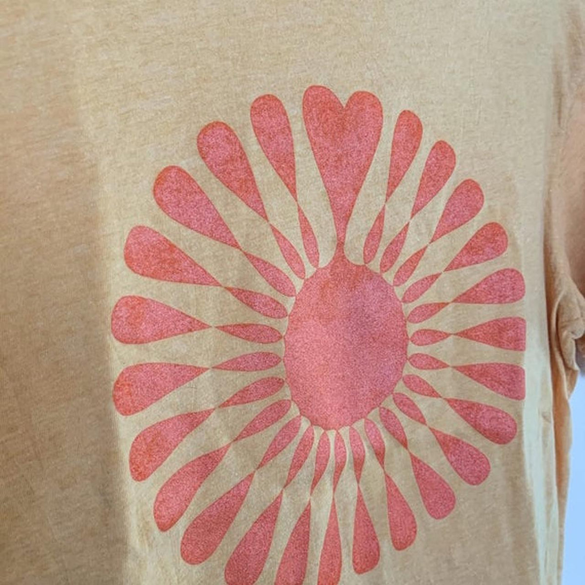 A t - shirt with a sun design on it.