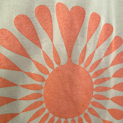 A close up of an orange and white sun t - shirt.