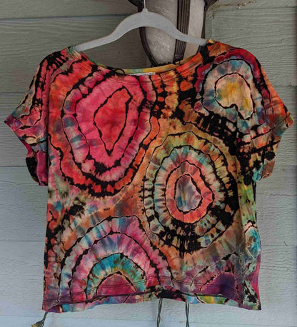 a tie dyed shirt hanging on a wall.