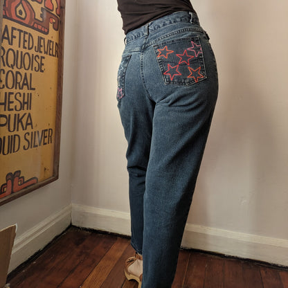 A woman is standing in a corner with her back to the camera wearing Rainbow Star Jeans.
