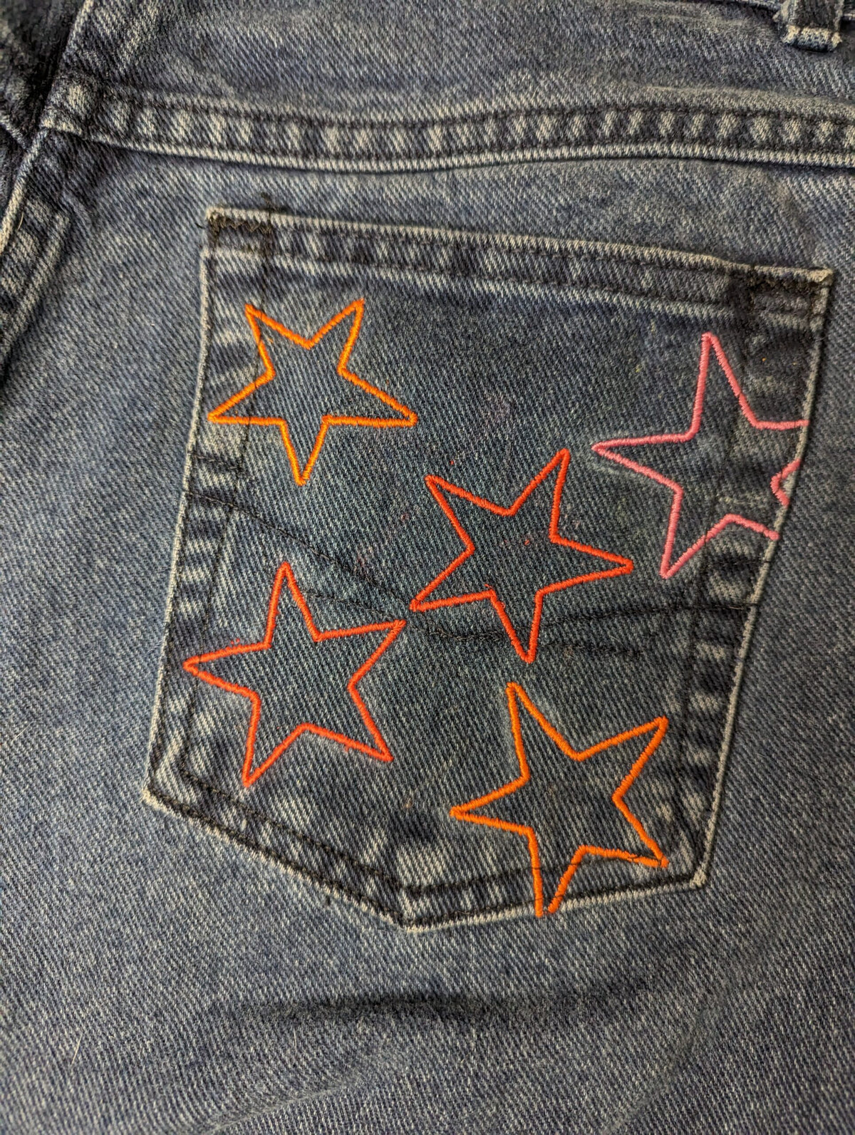 Rainbow Star Jeans with orange and pink stars on them.