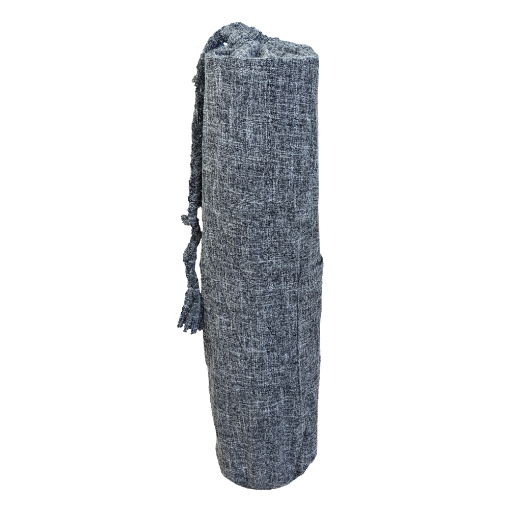 A grey yoga mat with tassels on it.