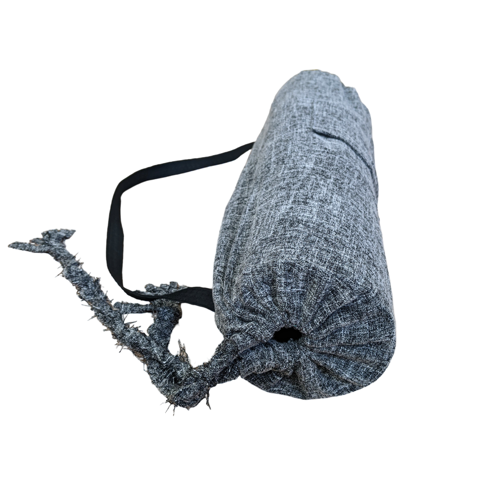 A grey yoga mat with a black strap.