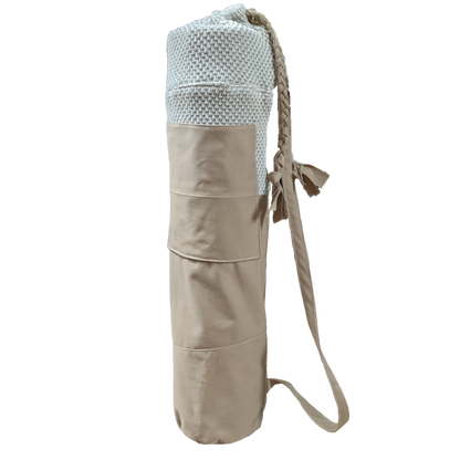 A beige yoga mat with a strap on it.