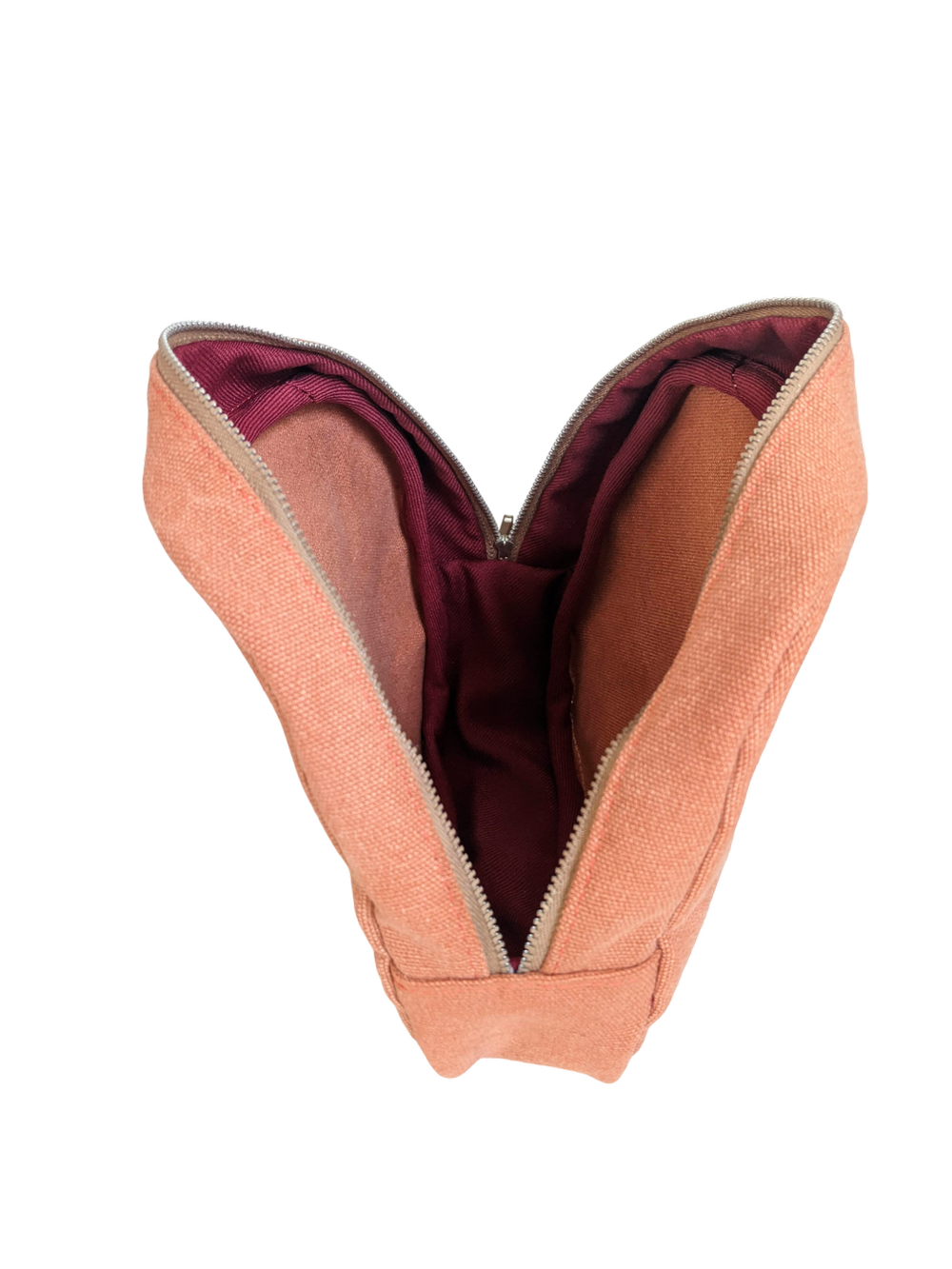 The inside of a peach pouch with a red zipper.